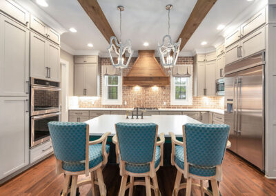 Modern luxury kitchen featuring a large white island with teal barstools